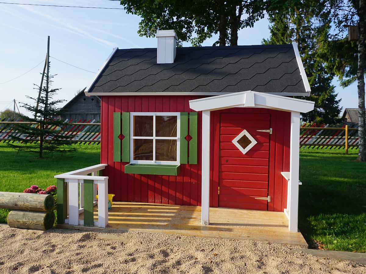 Front outside view of assembled wooden kids playhouse DIY Kit Little Cottage with black roof in a yard | outdoor playhouse DIY kit by WholeWoodPlayhouses