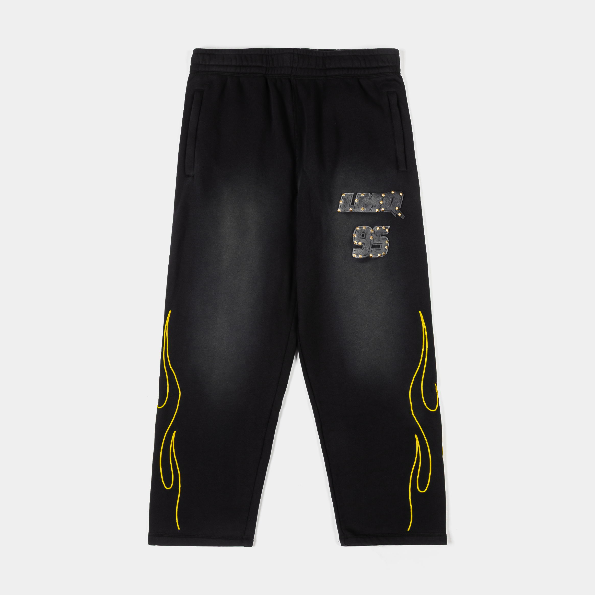 Black pants with yellow flame design and graphic text on the front.