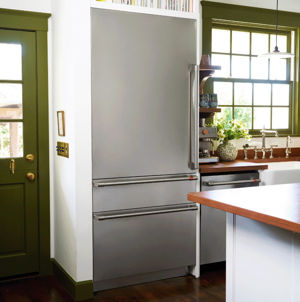 Modern kitchen with a stainless steel refrigerator and green door.