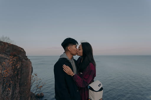 Francis and Carol kissing with ocean in background