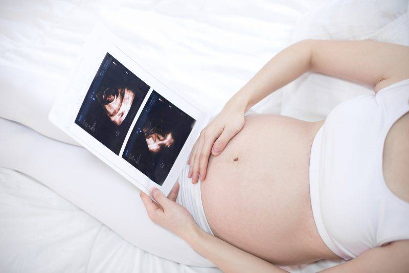 Woman Holding Pregnancy Photos