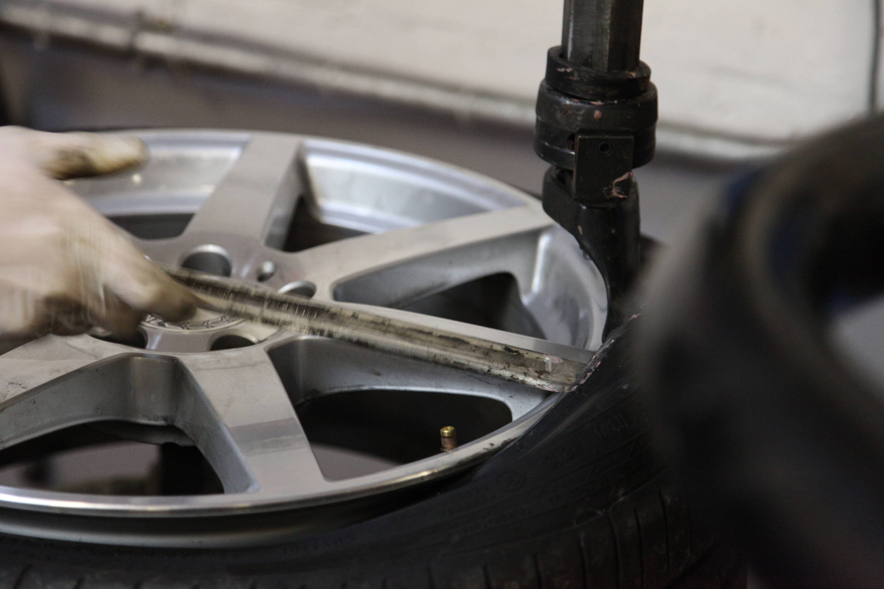 Car technician hand measuring tyre 