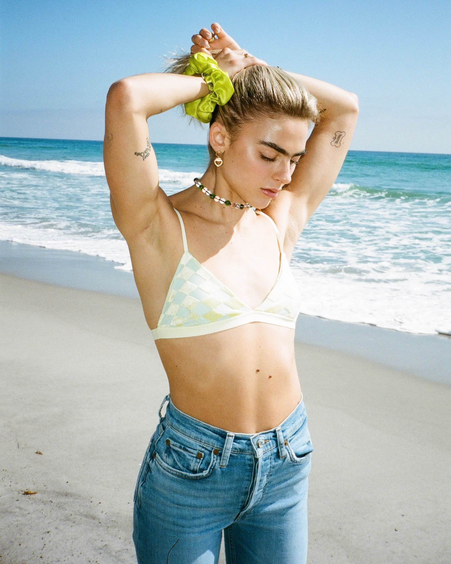 Model on the beach wearing Baserange, Re/Done, Laura Lombardi, Mondo Mondo and Kkco.