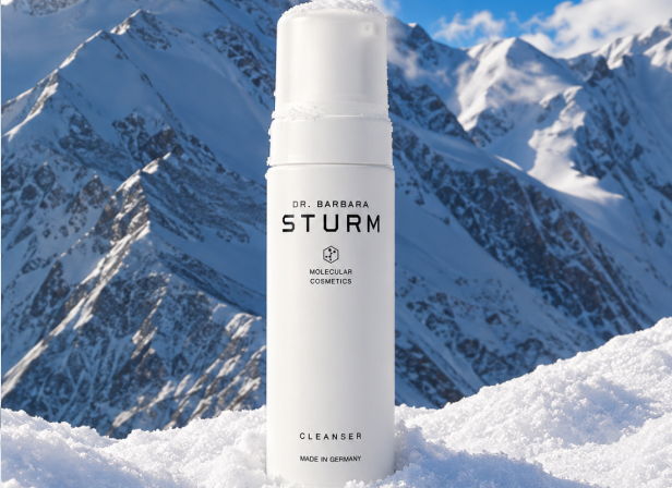 A skincare product in front of snowy mountains.