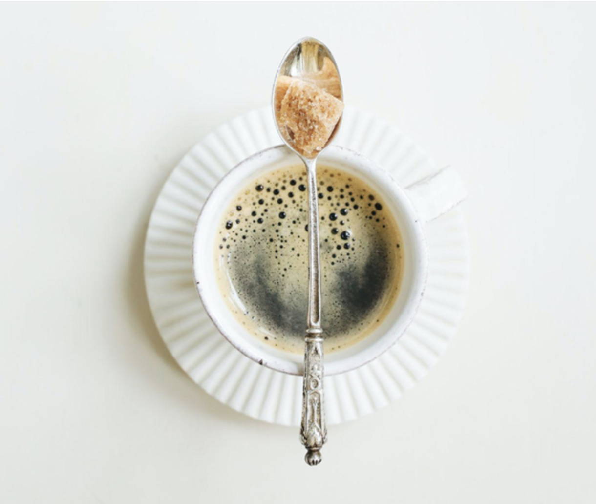 White coffee cup with coffee and spoon