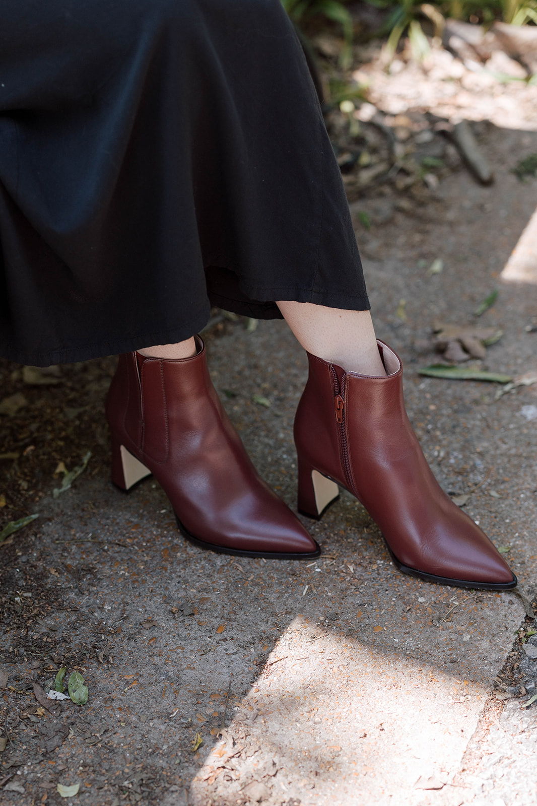 A pair of brown ankle boots on a person's feet.