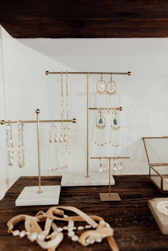 Earring drops and hoops on copper and marble display