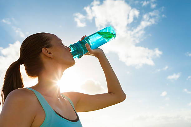 Woman drinking water. Woman hydrating. Workout recovery. Pre-workout. 