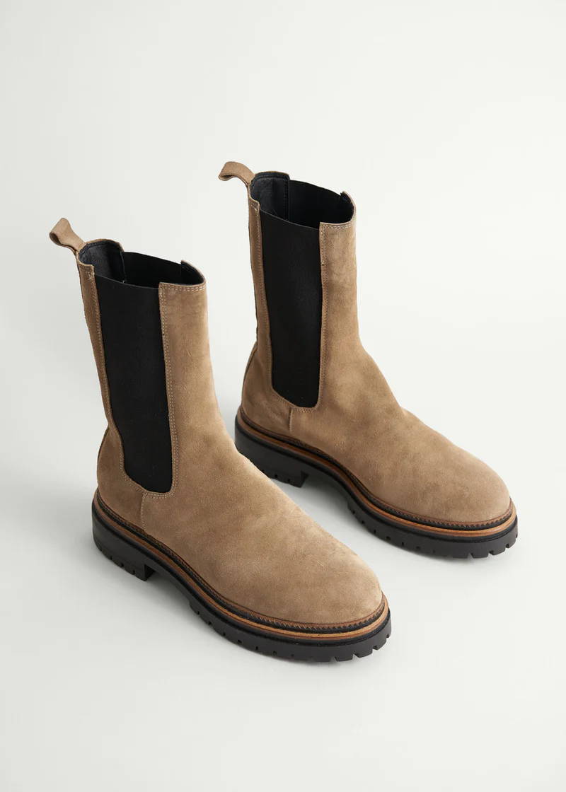 A pair of high top, taupe coloured, suede chunky chelsea boots