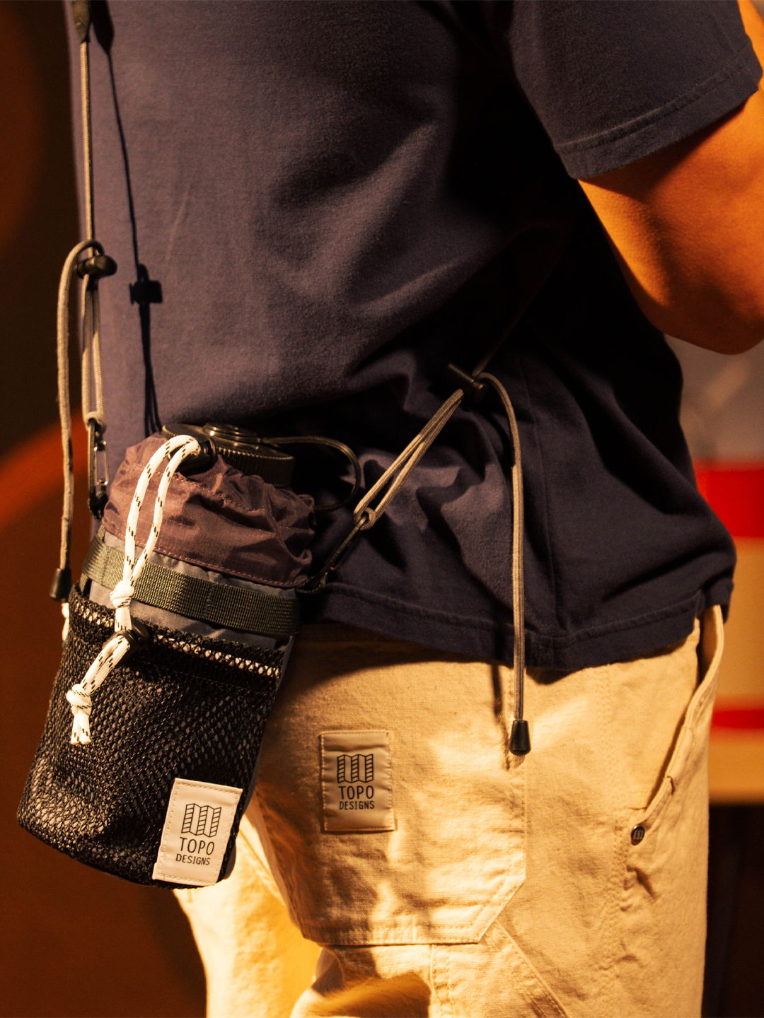 A person wearing a dark shirt with a pouch on their side.