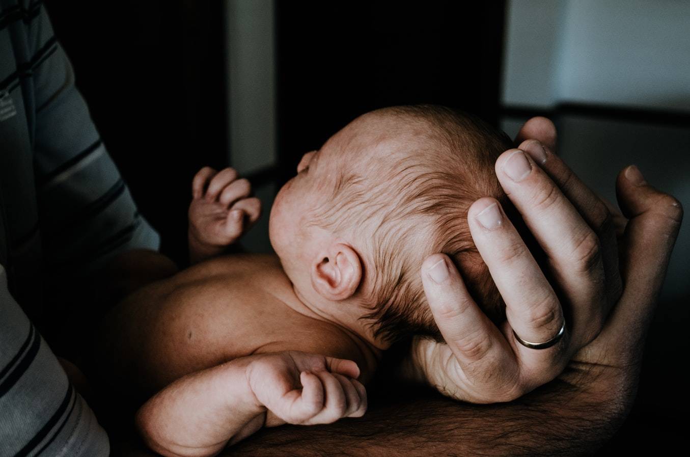 Man Holding New Born In His Hands