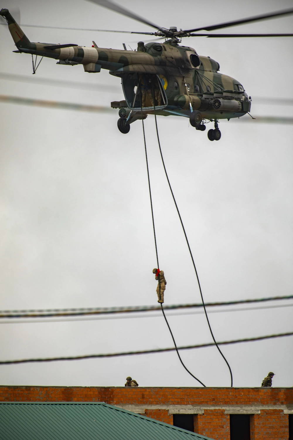 Ukrainian soldiers fast rope from a MI-8 helicopter, during Rapid Trident 2021. Soldiers from 15 nations participate in the exercise. Americans observe as Ukrainian, Polish, and Lithuanian soldiers conduct urban operations against Ukrainian OPFOR.