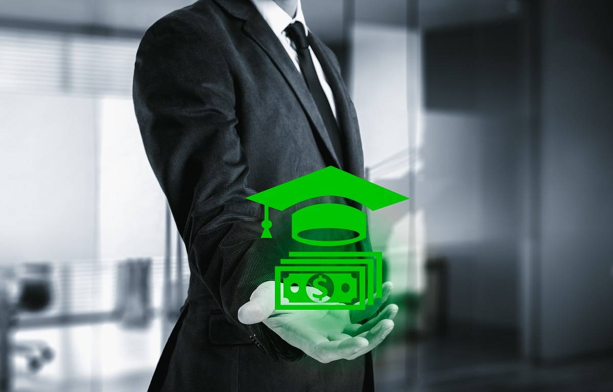 Man in a suit and tie holding a logo of a stack of money with  a graduation cap 