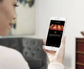 Woman using SmartHQ app to see inside oven