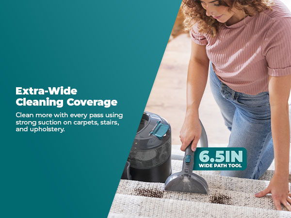 Person cleaning upholstery with a vacuum cleaner, showcasing extra-wide cleaning coverage.