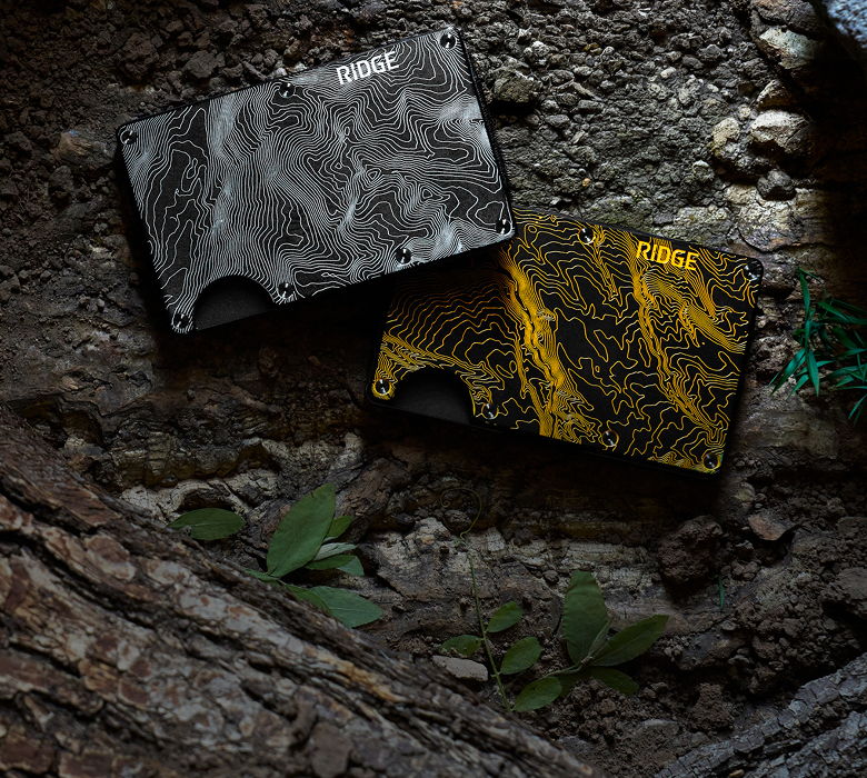 Two wallets, one black and one yellow, on textured ground.