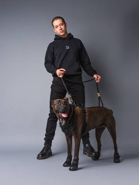 main in black hoodie with black dog