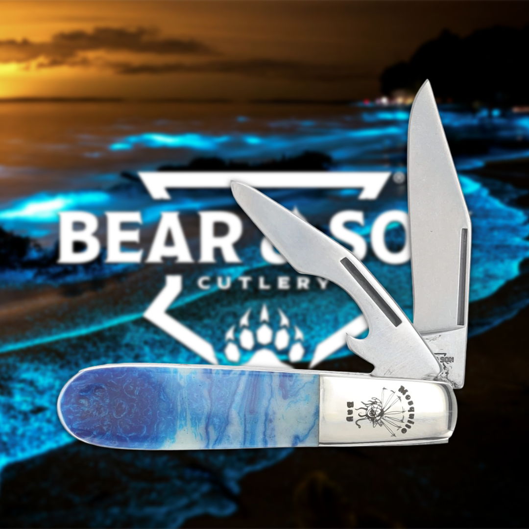 A folding knife with a blue handle against a scenic background.
