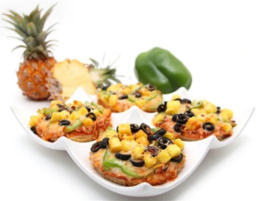 Colorful mini pizzas with pineapple, bell pepper, and black beans on a white plate.