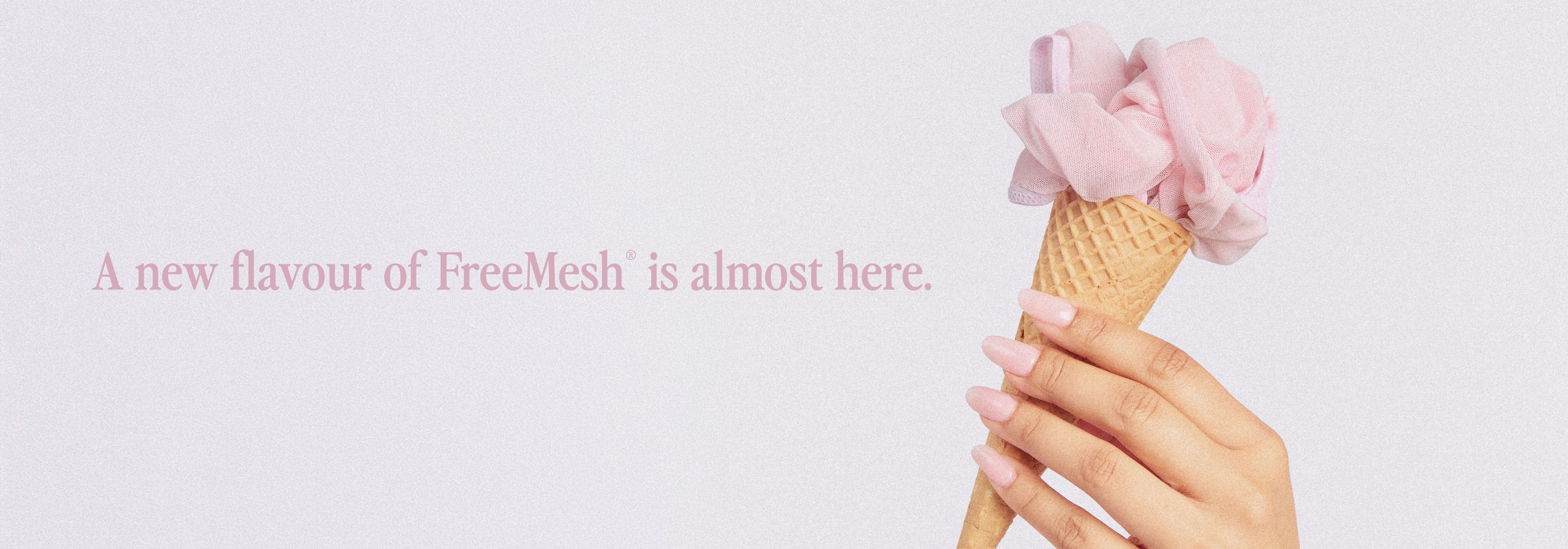A hand holding an ice cream cone with pink topping.