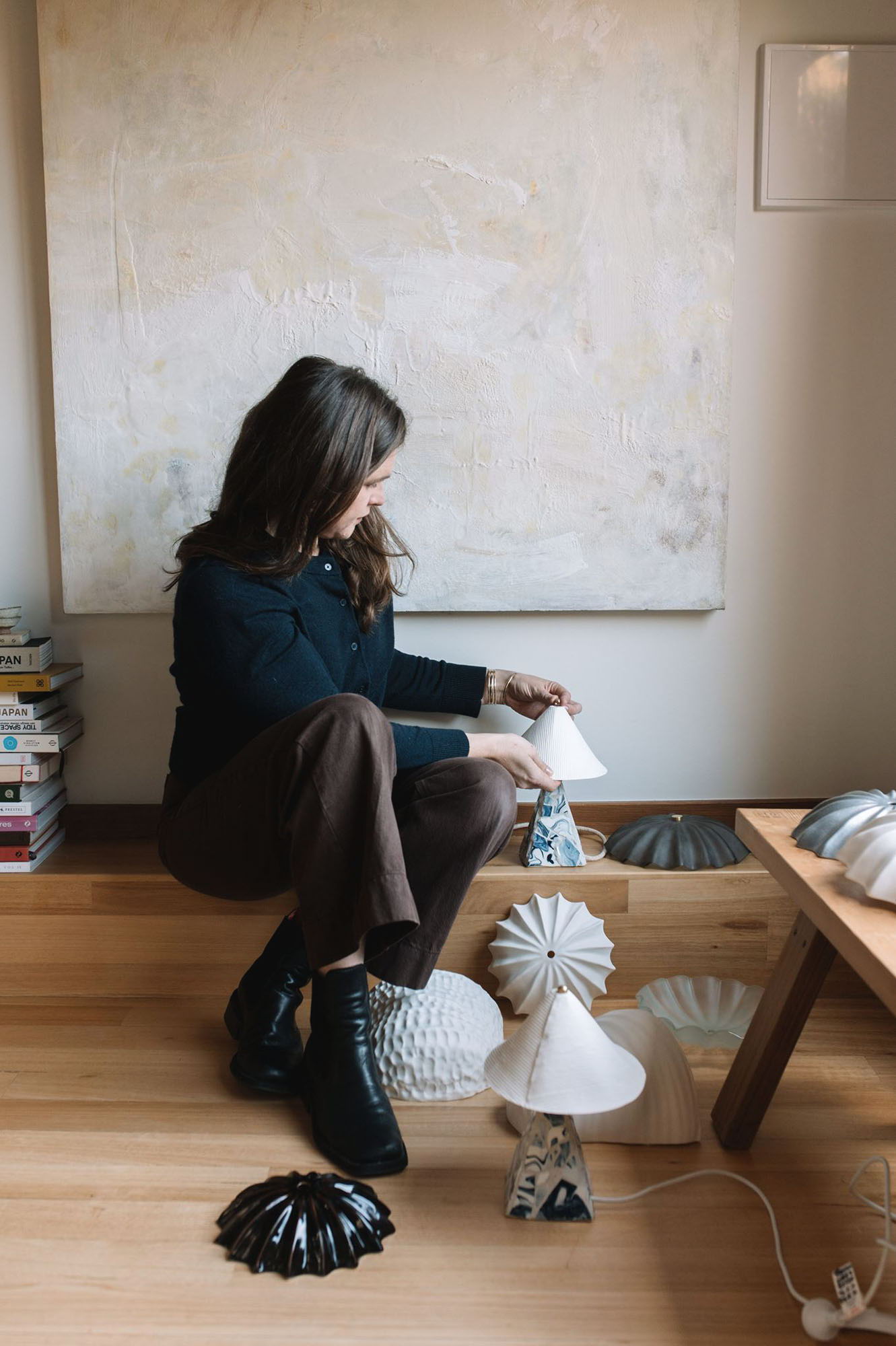 Milly Dent with her lights in a well-lit room with wooden flooring.