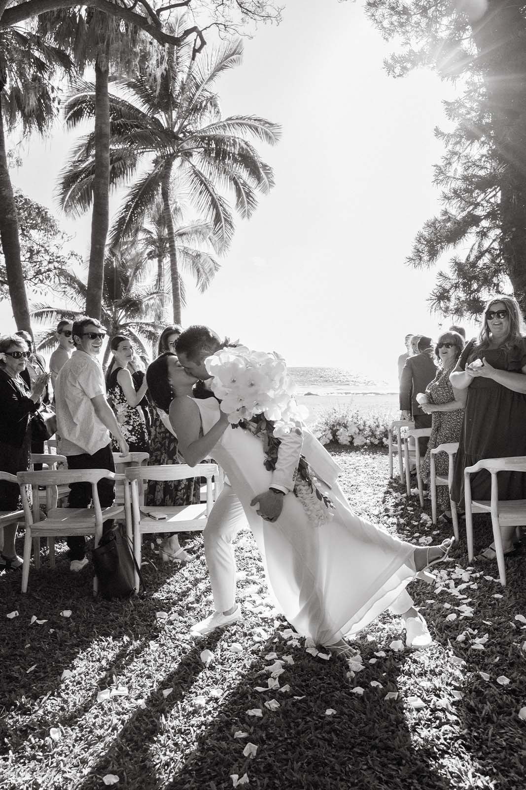 Groom dipping his bride at ceremony