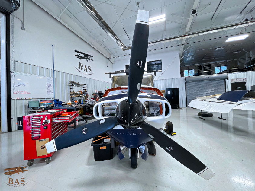 Helicopter in a hangar with tools and equipment around.