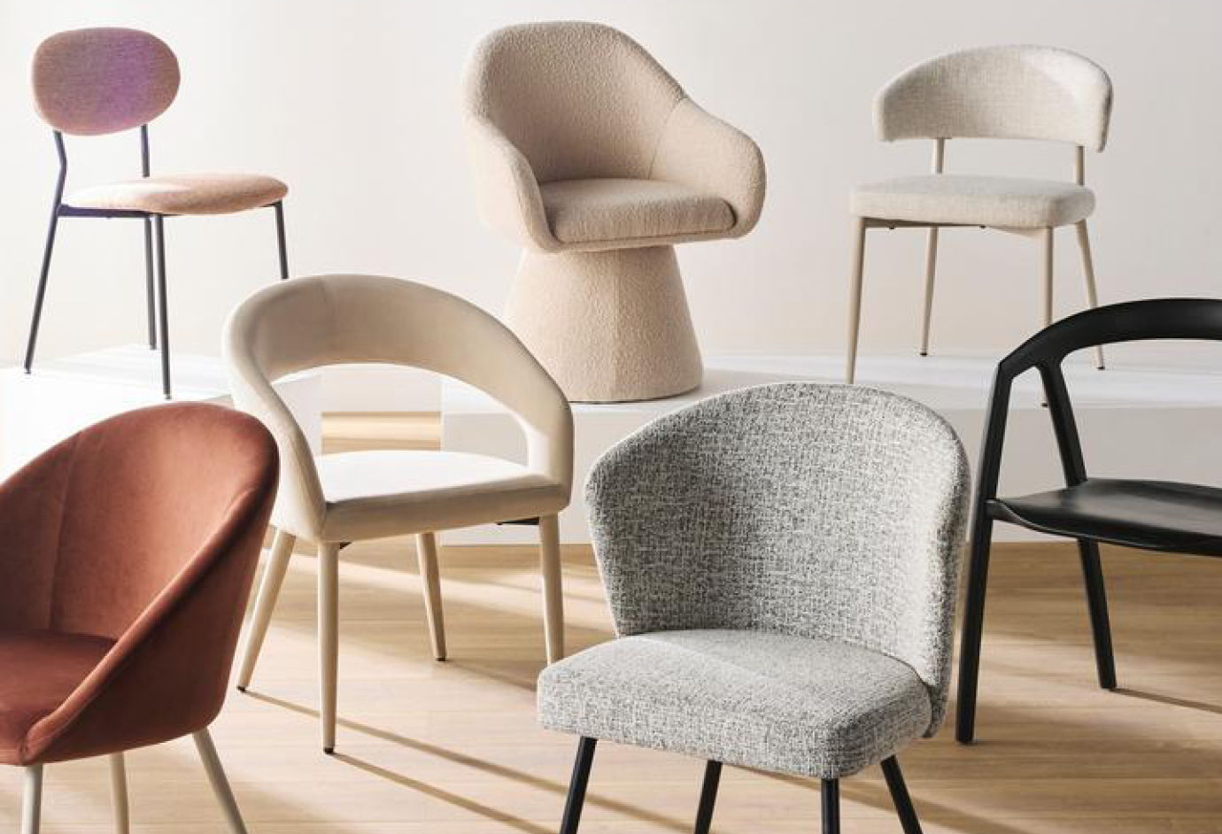 Various stylish chairs in different colors and designs on a wooden floor.