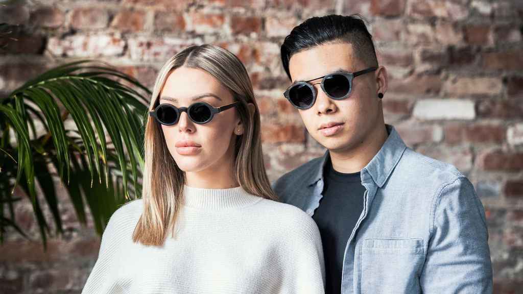 Homme et femme portant des lunettes de soleil en bois
