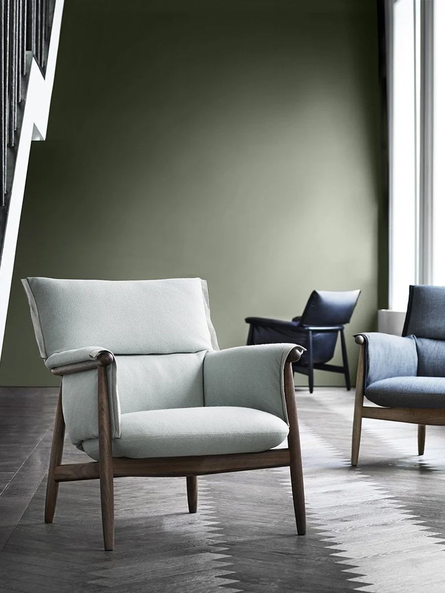 Two stylish Carl Hansen chairs in a modern interior with green wall.