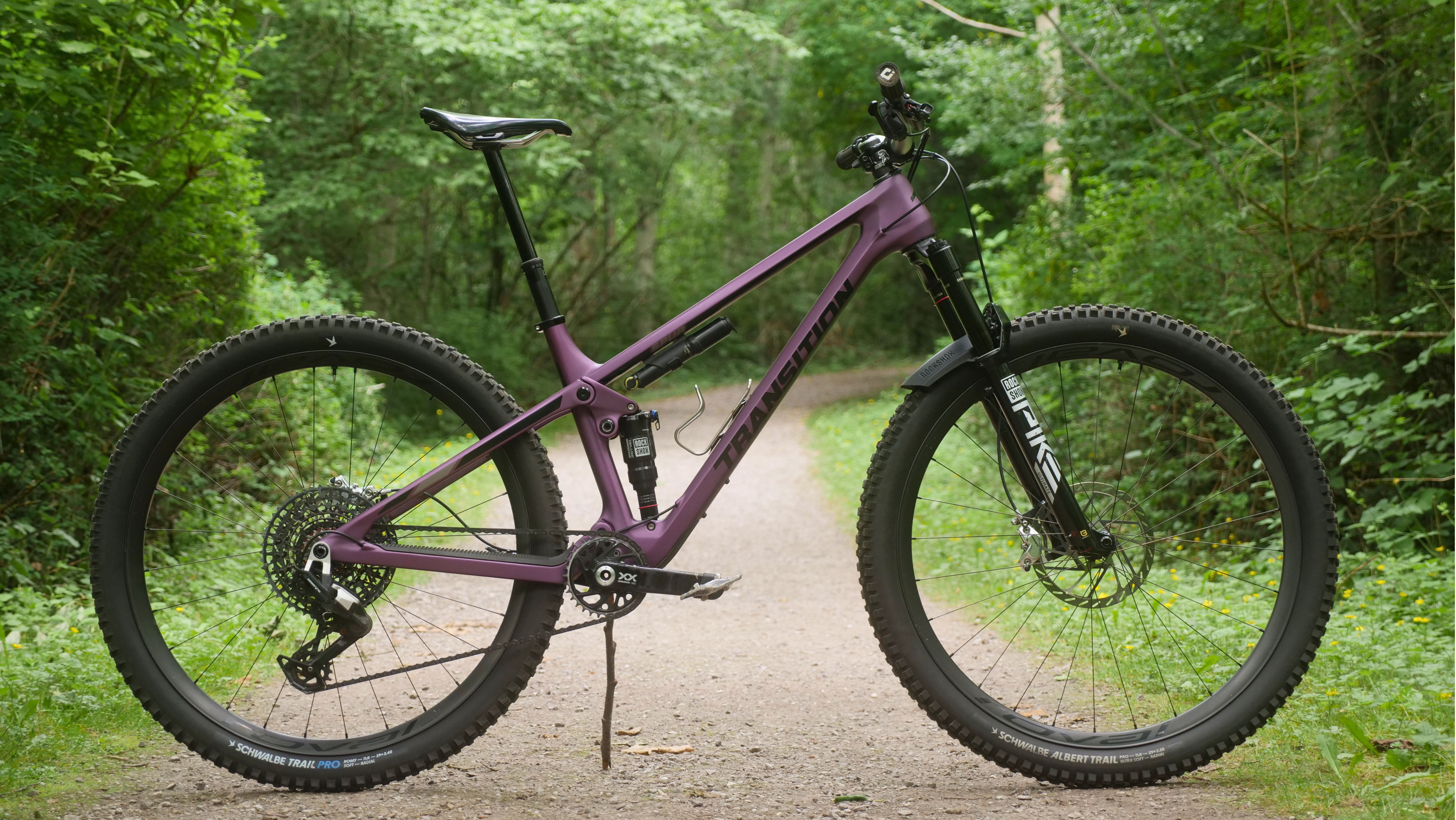 Mountain bike on a dirt path surrounded by trees.