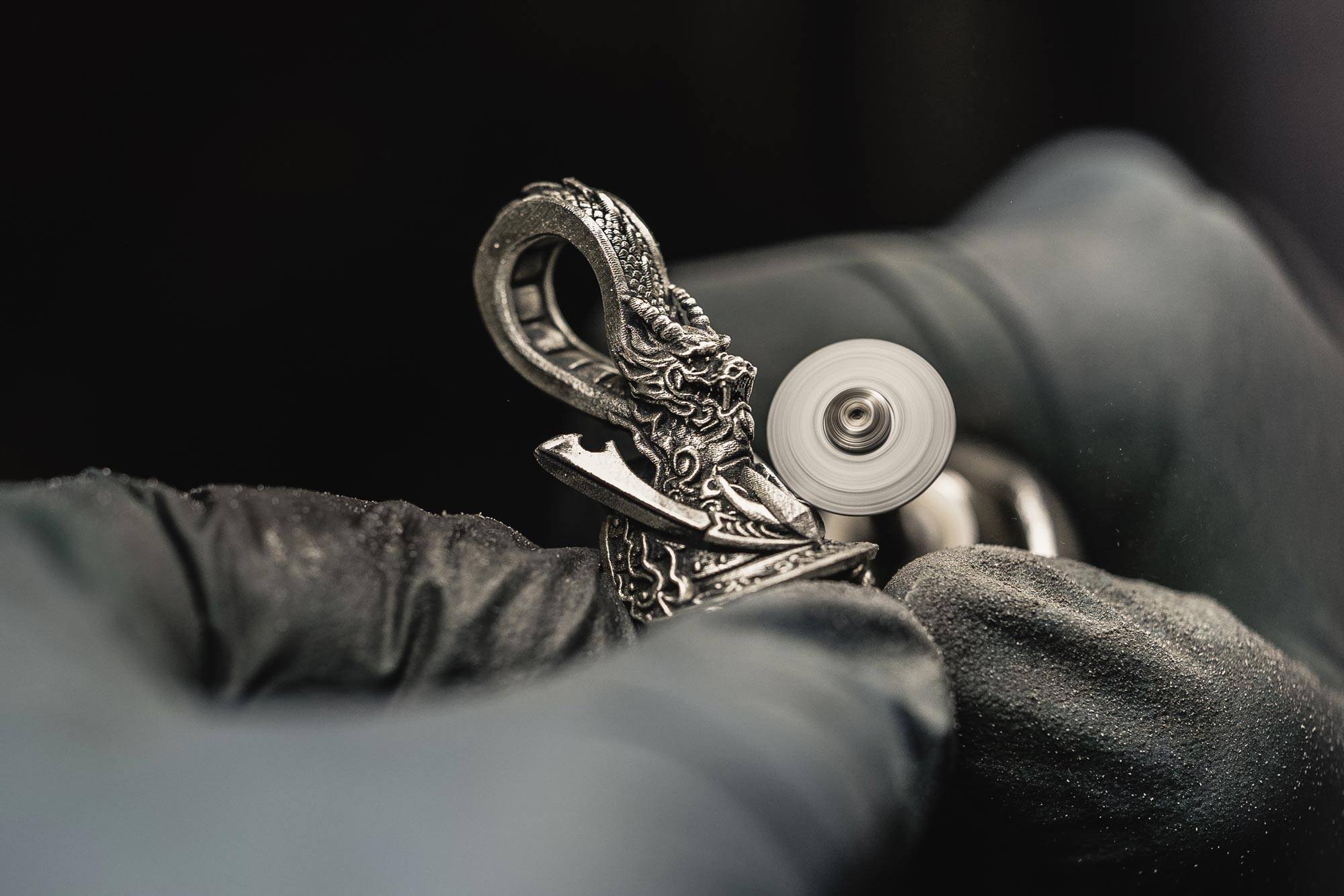 Close-up of a NightRider Jeweler hand finishing the Bushido Pendant
