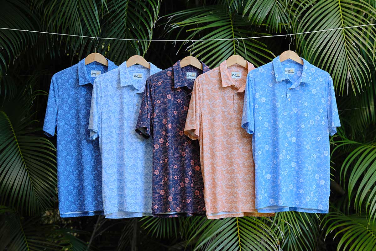 Four colorful short-sleeve shirts hanging against a tropical backdrop.