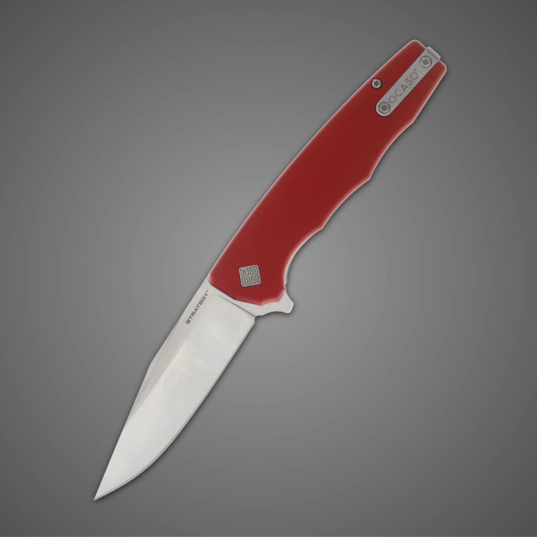 A red-handled folding knife with a shiny blade on a grey background.