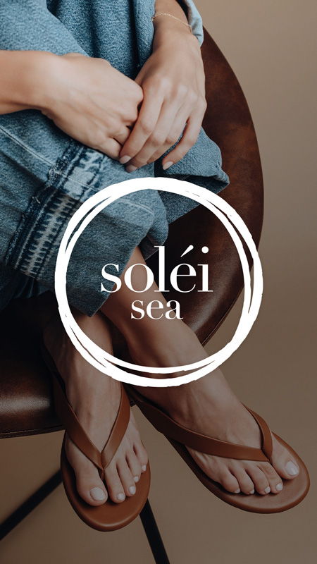 Person wearing flip-flops sitting on a chair with brand logo.