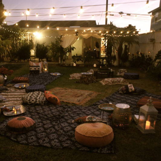 Outdoor garden with cosy seating, lanterns and festoons.