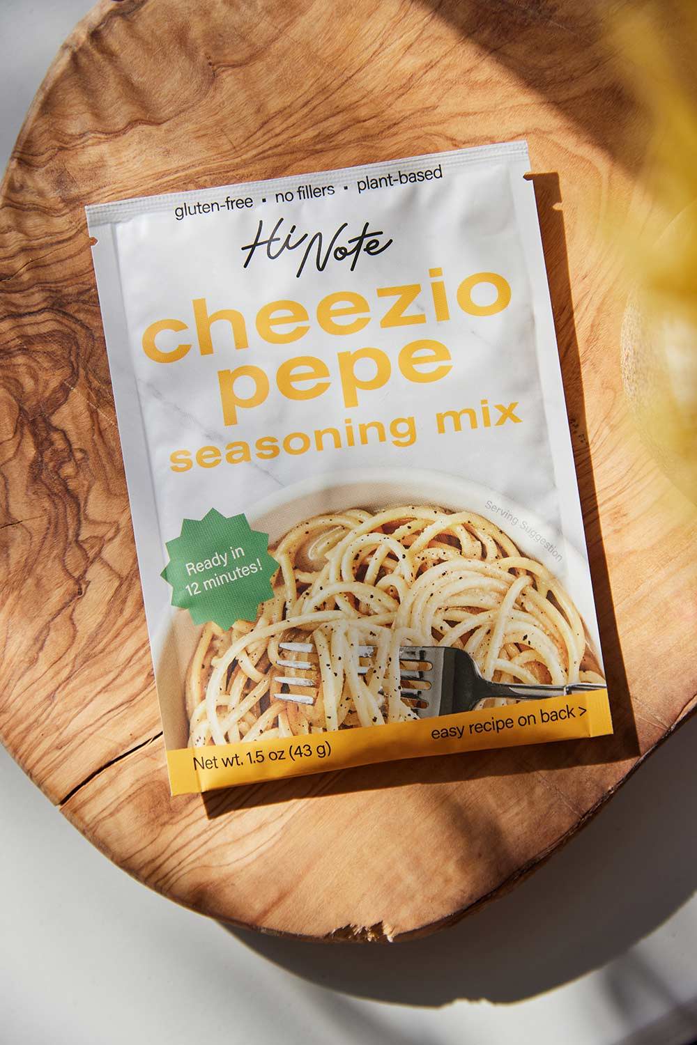 A packet of Cheezio Pepe sitting on a wooden cutting board.