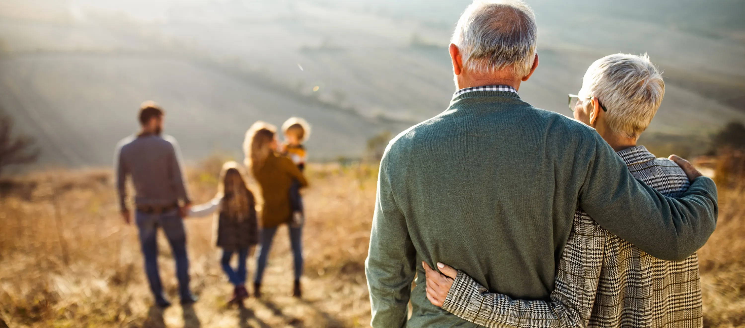 Older couple watching kids and grandkids hiking