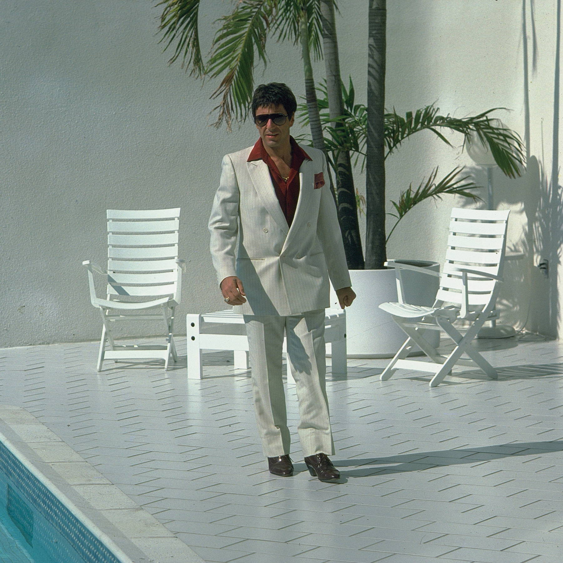 tony montana white suit next to pool