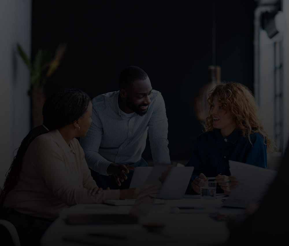 Office professionals collaborating in a modern workspace, representing security and monitoring solutions for office buildings and corporate environments