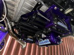 Undercarriage view of custom HornBlasters train horn kit with black trumpets, glossy metallic purple air tank, and purple mounting brackets
