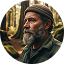 Man with a beard wearing a beanie in a forest setting.