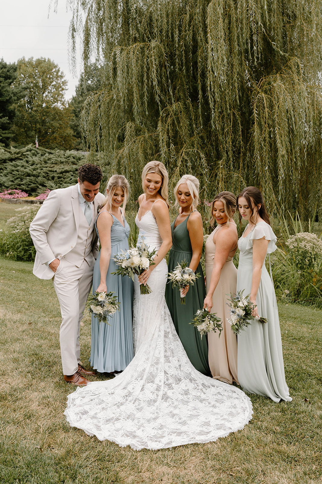 Bride and bridesmaids posing together in a garden setting.