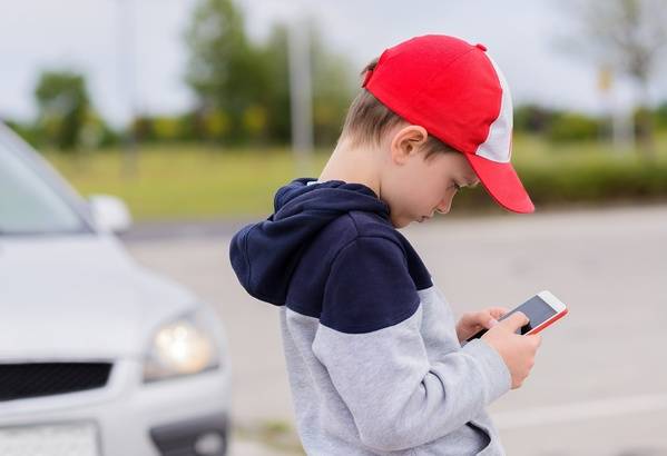 Student crossing the street while texting