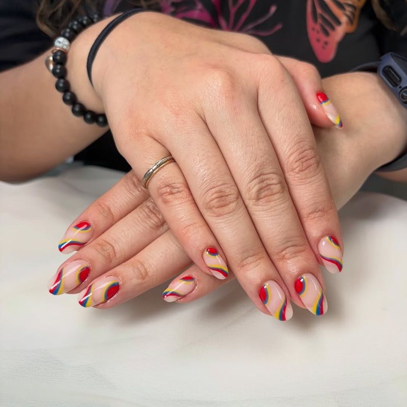 Hands with colorful nail art featuring swirls of red, yellow, and purple.