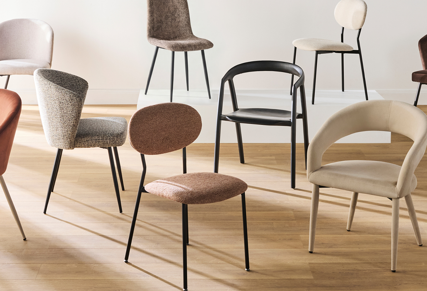 Various stylish chairs arranged on a wooden floor.