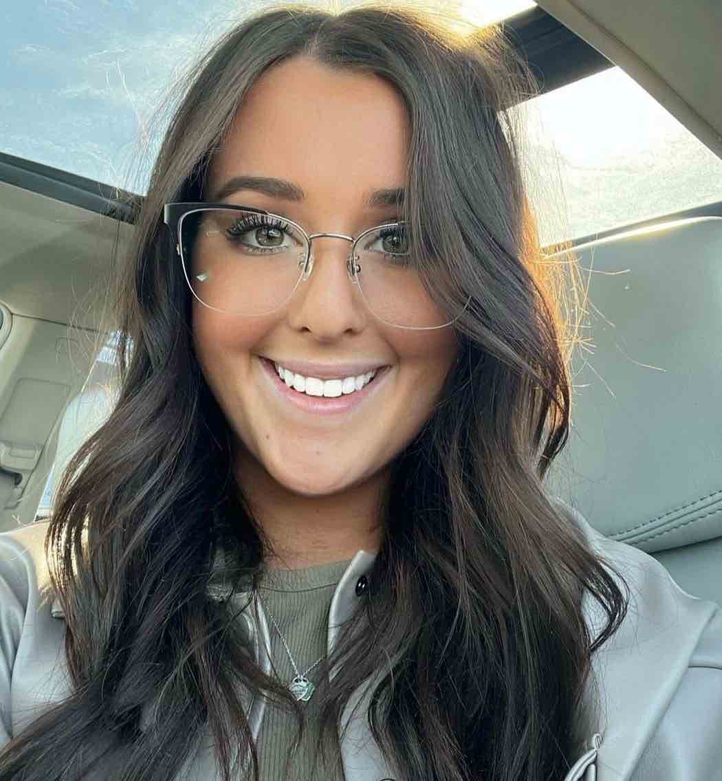 Smiling Woman with big nose wearing Enchanted Silver, Cat-Eye Eyeglasses in Silver Metal with a light green shirt and jacket