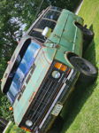Front three-quarter faded green patina Dodge Ram van CREEP Maine plate sun visor roof rack grass Brandon's Flatlaw 3 Liter featured gallery photo 1