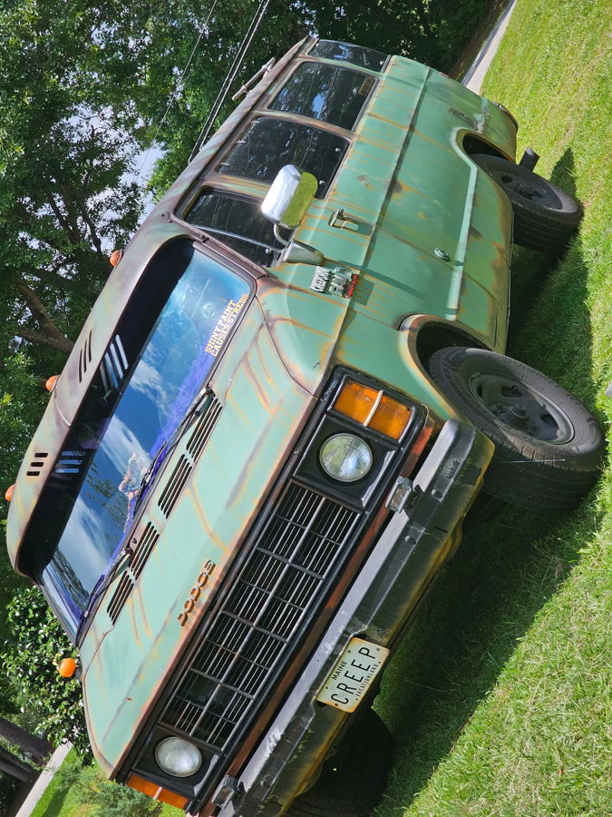 Front three-quarter faded green patina Dodge Ram van CREEP Maine plate sun visor roof rack grass Brandon's Flatlaw 3 Liter featured gallery photo 1