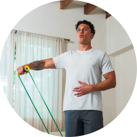 Man exercising with resistance bands in a bright room.